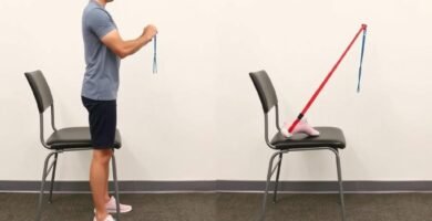 Person performing standing hamstring curls with resistance band for knee injury recovery exercises step by step
