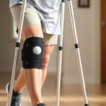 Person with MCL sprain using crutches with a knee brace for support during recovery