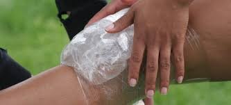 Person applying ice pack to knee with proper positioning